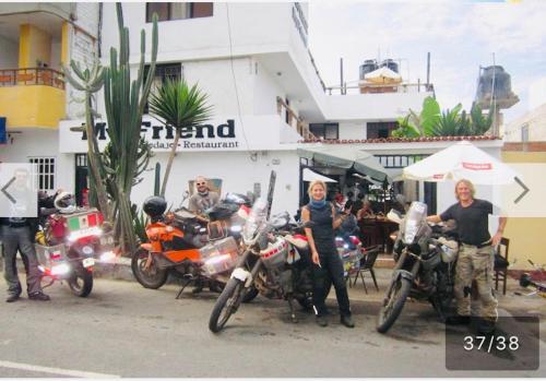 a group of people standing in front of motorcycles at Surf hostel My Friends in Huanchaco