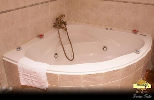 a bath tub with a towel on the side of it at Rincón de Doña Inés in Villanueva de la Condesa