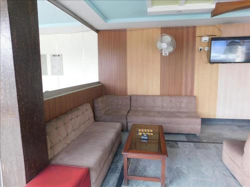 uma sala de estar com um sofá e uma mesa em Hotel Da Ville em Abbottabad