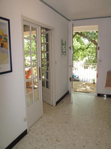 an empty room with a door open to a patio at Résidence Miro, gîtes climatisés avec piscine et tennis in Les Arcs sur Argens