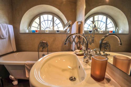 bagno con vasca, lavandino, vasca e specchio di Torre dei Lari Residenza d'Epoca a Firenze