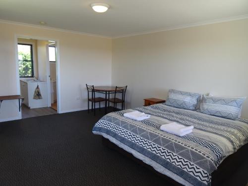 a bedroom with a bed with two towels on it at Redgate Country Cottages in Moffatdale