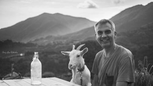 a man standing next to a goat next to a bottle at Kumano Winery Guest House in Tanabe