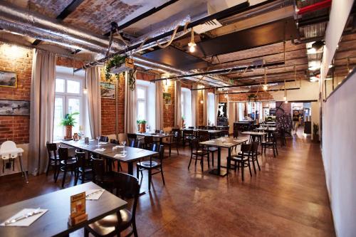 a restaurant with wooden tables and chairs and brick walls at Koszary Arche Hotel in Góra Kalwaria