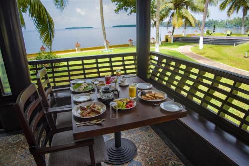 庫瑪拉孔的住宿－The World Backwaters, Alleppey，一张带食物的桌子,享有海景