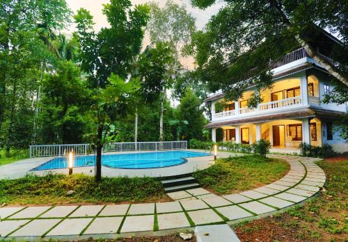 a house with a swimming pool in front of it at Once Upon The River, Aluva - Near Cochin International Airport in Cochin