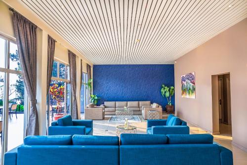 a living room filled with furniture and a blue couch at Hotel des Mille Collines in Kigali