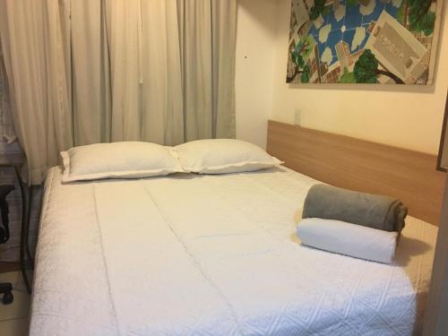a bed with white sheets and pillows in a room at Life Resort - Flat Aconchegante in Brasília