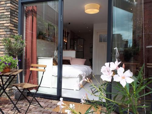 a room with a bed on a patio with glass doors at Het Gindrahuis in Bladel