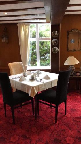a dining room table with two chairs and a window at Gable End Hotel in Great Yarmouth