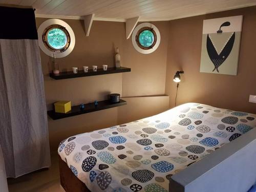 une chambre avec un lit et deux fenêtres dans l'établissement Le grand large, à Metz