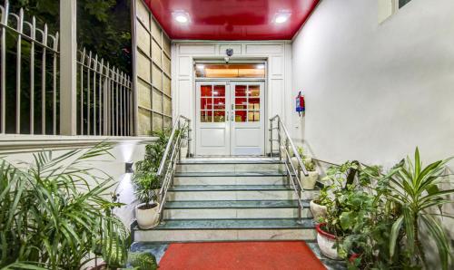 una escalera que conduce a una puerta blanca con plantas en Treebo Trend Mall View DLF Phase II en Gurgaon