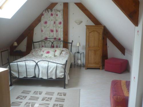 a bedroom with a bed in a attic at chambre d'hôte équipée en studio in Molliens-Vidame