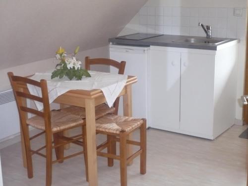 cocina con mesa, 2 sillas y fregadero en chambre d'hôte équipée en studio, en Molliens-Vidame