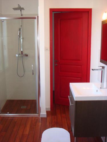 La salle de bains est pourvue d'une porte rouge et d'une douche. dans l'établissement 20 rue Edouard Corbière, proche gare SNCF de BREST, à Brest