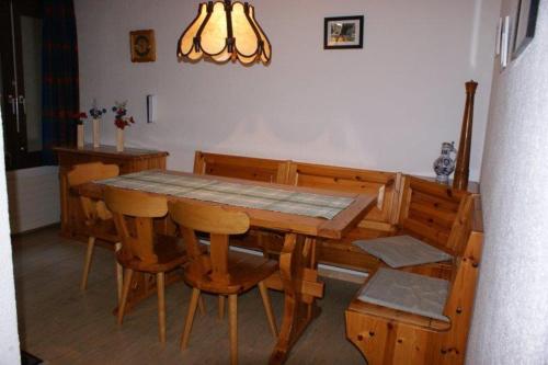 een houten eettafel en stoelen in een kamer bij Lärchenwald 1706 in Leukerbad