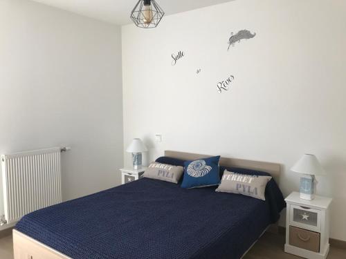 une chambre avec un lit avec une couette bleue dans l'établissement Les Amarres Aiguillon, à Arcachon