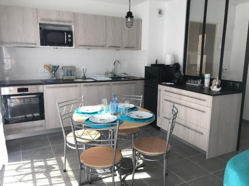 une cuisine avec une table et des chaises dans une cuisine dans l'établissement Les Amarres Aiguillon, à Arcachon