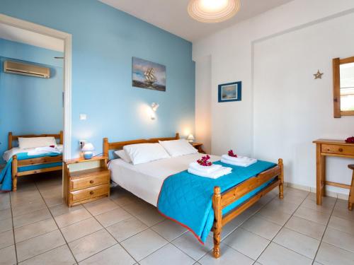 ein Schlafzimmer mit einem Bett mit blauen Wänden in der Unterkunft Calypso Studios in Ammoudi