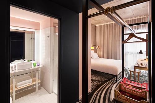 a hotel room with a bed and a bathroom at Mama Shelter Lille in Lille