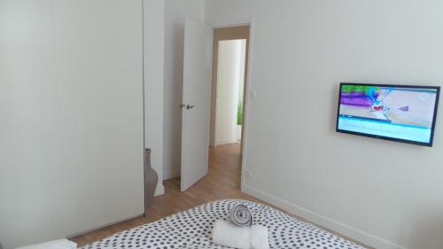 a living room with a tv on a wall at 20 rue Gasté, proche gare SNCF de BREST in Brest