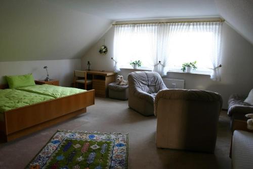een slaapkamer met een bed, een stoel en een bureau bij Haus Moorkamp in Celle