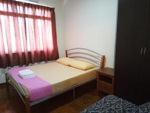 un petit lit dans une chambre avec une fenêtre dans l'établissement Aiman Homestay Port Dickson, à Port Dickson