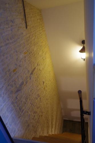 a stairway with a brick wall and a lamp at Les Lavandières in Saint-Hilaire-la-Palud