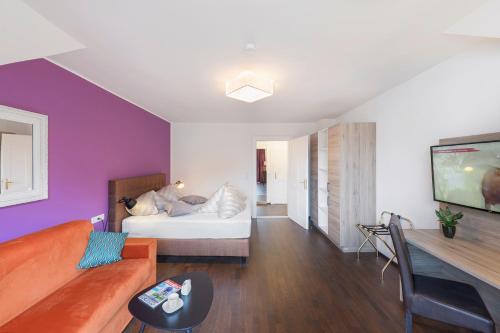 a living room with a couch and a tv at Villa Maria - Suiten & Appartement in Kufstein