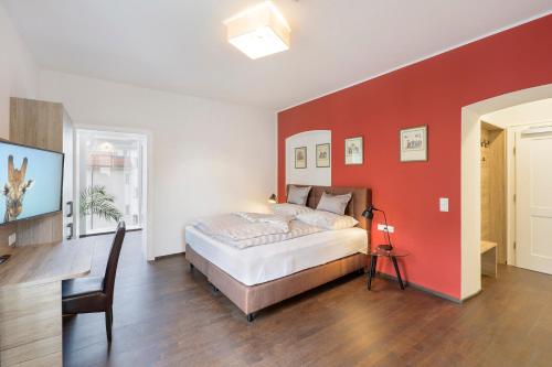 a bedroom with a bed and a red wall at Villa Maria - Suiten & Appartement in Kufstein