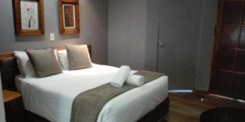 a bedroom with a large white bed with pillows at Waterside Lodge CC in Piet Retief