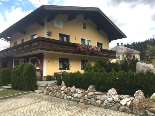 ein großes gelbes Haus mit Balkon oben in der Unterkunft Haus Gsenger in Abtenau