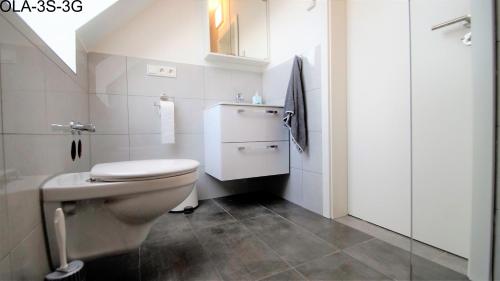 a white bathroom with a toilet and a sink at Overath Luxus Apartments nähe Köln City/Messe in Overath