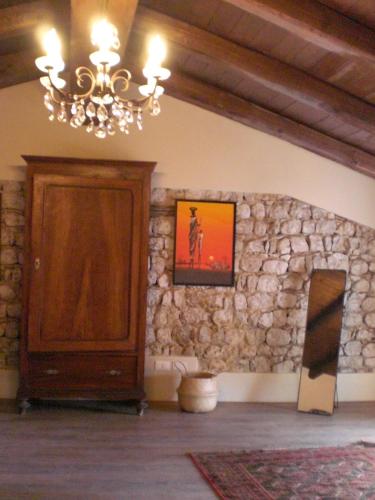 a living room with a chandelier and a stone wall at Venezia delle Nevi in Budòio