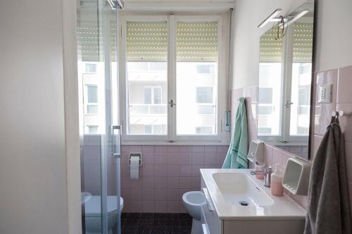 a bathroom with a sink and a toilet and a window at Paola's Home in Trieste