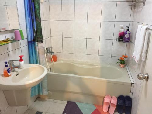 a bathroom with a bath tub and a sink at Sunny House II in Guilin