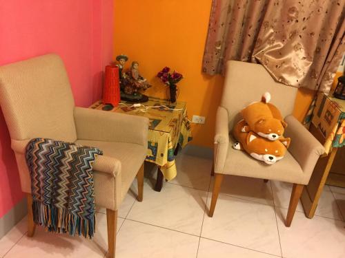 a room with two chairs and a table with a stuffed animal at Sunny House II in Guilin