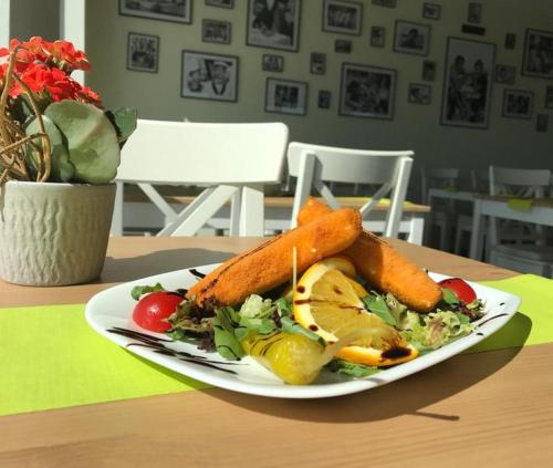 a plate of carrots and salad on a table at Intergroup Business & Design Hotel Ingolstadt in Kösching