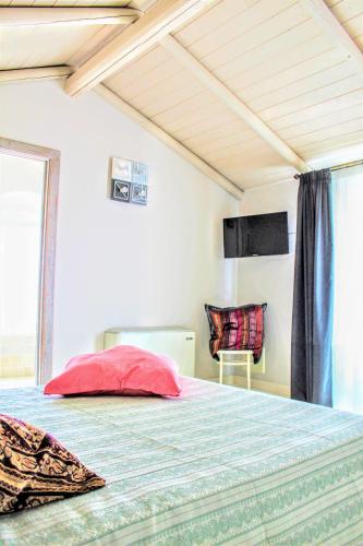 a bedroom with a bed with a red pillow on it at Dimora Vico dei Nohi in Lecce