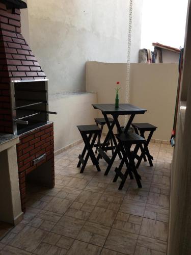 a table and chairs in a room with a stove at Hospedagem Aconchego in Cunha