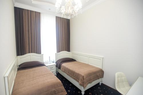 a bedroom with two beds and a chandelier at Петрівський in Kropyvnytskyi