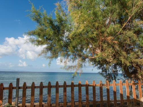 a fence and a tree on the beach at Calypso Studios in Amoudi
