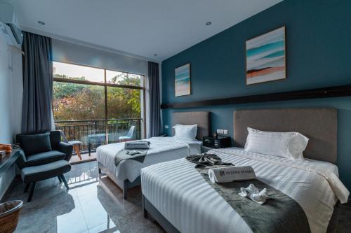 a hotel room with two beds and a chair at Bohol Panglao Begonia Resort in Panglao
