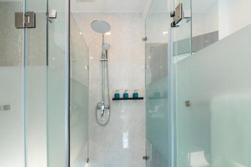 a shower with a glass door in a bathroom at Bohol Panglao Begonia Resort in Panglao