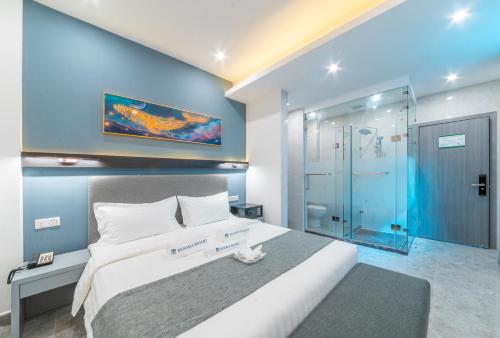 a bedroom with a large bed and a glass shower at Bohol Panglao Begonia Resort in Panglao