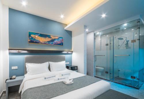 a bedroom with a large bed and a glass shower at Bohol Panglao Begonia Resort in Panglao