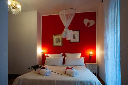 a bedroom with a red wall and a bed at B&B Buonfiglio Cicconcelli - Terrazza panoramica in Frascati