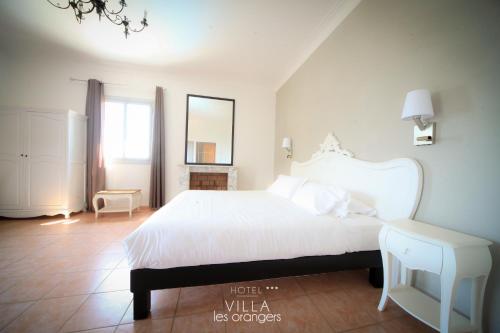 Un pat sau paturi într-o cameră la Hôtel Villa Les Orangers