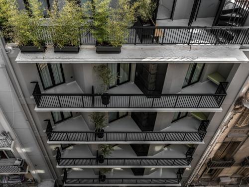 un edificio de apartamentos con balcones con plantas. en Mosaikon en Atenas