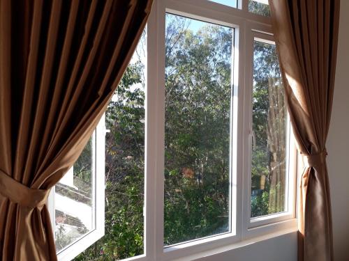 a window with curtains in a room at Caly homestay in Da Lat